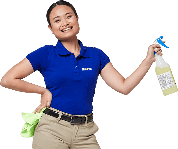 a woman smiling in JAN-PRO Cleaning & Disinfecting shirt holding a bright green cloth and spray bottle